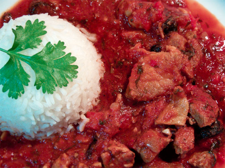 Adoboloco Pastele Stew served with Jasmine Rice and garnished with fresh cilantro.